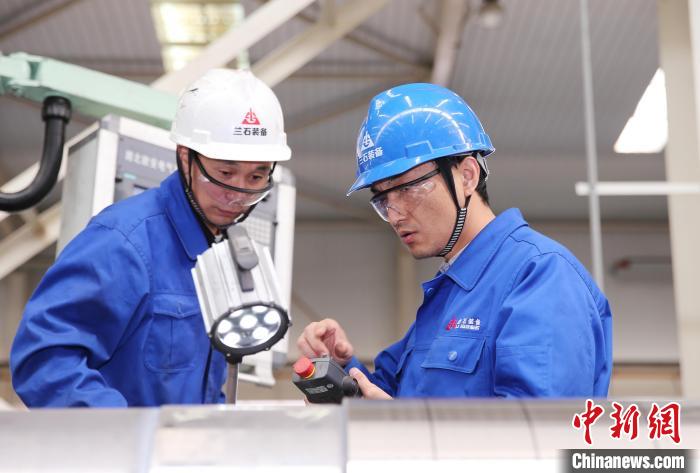 图为邹斌(右一)给徒弟讲解车床加工注意事项。 (资料图) 兰石集团供图 图为邹斌(右一)给徒弟讲解车床加工注意事项。 (资料图) 兰石集团供图