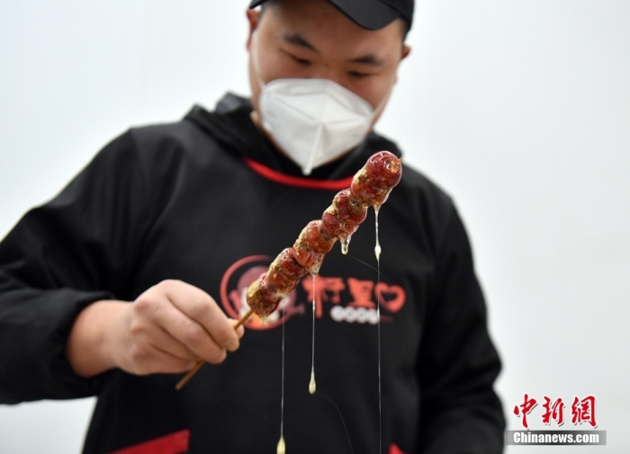 雄安新区大树刘庄村辛爱青家中的冰糖葫芦加工厂，工人正在制作冰糖葫芦。作为远近闻名的“冰糖葫芦村”，大树刘庄村制作冰糖葫芦的历史已有100多年，全村三分之二的村民都会这门手艺，吸引不少游客慕名而来。 中新社记者 韩冰 摄